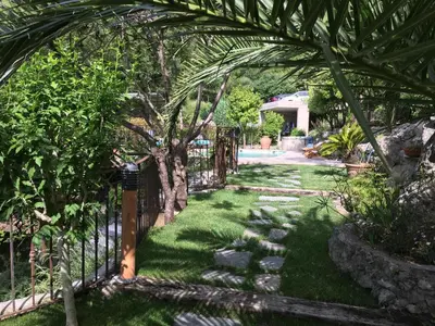 a group of chairs and an umbrella next to a pool at La Romarine in Falicon