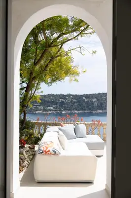 a white couch sitting under an archway with a tree at Villa Belvedere in Nice