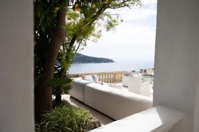 a white couch sitting on a balcony overlooking the ocean at Villa Belvedere in Nice