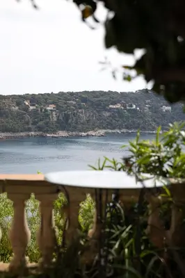 a table on a balcony with a view of the water at Villa Belvedere in Nice