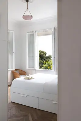 a white bedroom with a large bed and a window at Villa Belvedere in Nice
