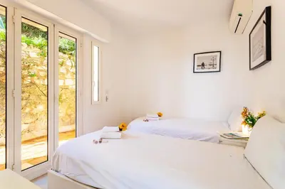 two beds in a white room with a window at HENRIETTA AP4070 - avenue Soleil d'Or - Villefranche-sur-Mer in Villefranche-sur-Mer