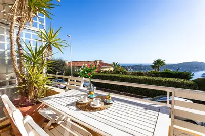 a table on a balcony with a view of the ocean at HENRIETTA AP4070 - avenue Soleil d'Or - Villefranche-sur-Mer in Villefranche-sur-Mer