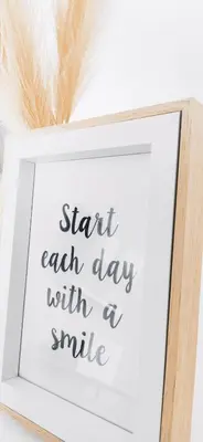 a framed picture of start each day with a smile with feathers at Nuances d'Azur - Bel Azur in Nice