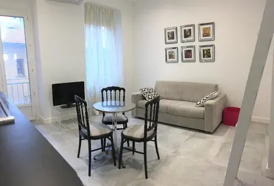 a living room with a couch and a table and chairs at Heart of Nice Harboor cosy and central in Nice