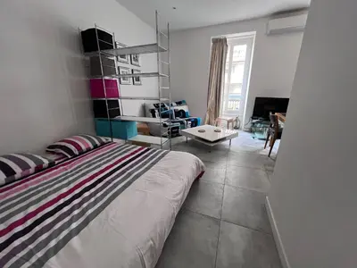 a bedroom with a bed and a living room at Heart of Nice Harboor cosy and central in Nice