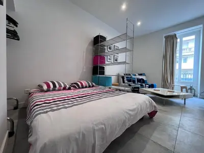a bedroom with a large bed and a chair at Heart of Nice Harboor cosy and central in Nice