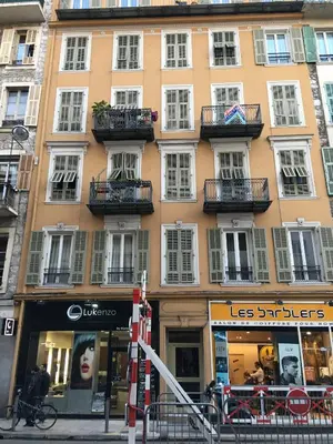 a tall building with windows and balconies on a street at Heart of Nice Harboor cosy and central in Nice