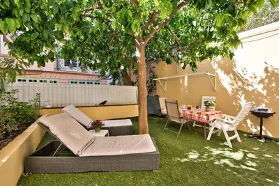 a garden with a table and chairs and a tree at la palais osiris Nice centre jardin wifi clim parking in Nice
