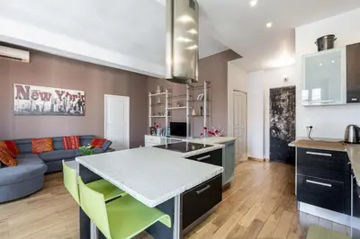 a kitchen and living room with a table and a couch at Le Blacas in Nice