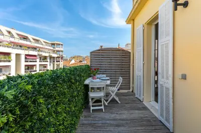 a wooden deck with a table and chairs on a balcony at Le Blacas in Nice