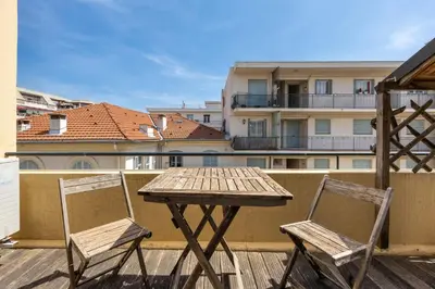 a wooden table and two chairs on a balcony at Le Blacas in Nice