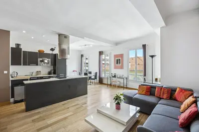 a living room with a couch and a kitchen at Le Blacas in Nice