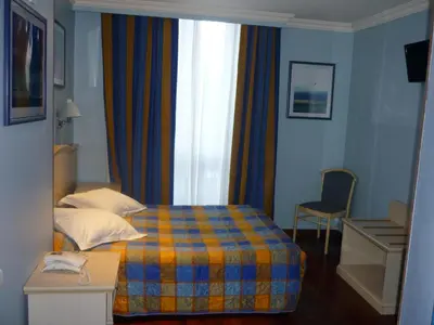 a hotel room with a bed and a window at Antares hostel in Nice