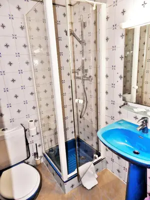 a bathroom with a shower and a blue sink at Antares hostel in Nice