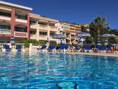a swimming pool with chairs and umbrellas in front of a hotel at Nyrenoverad lägenhet med havsutsikt in Villefranche-sur-Mer