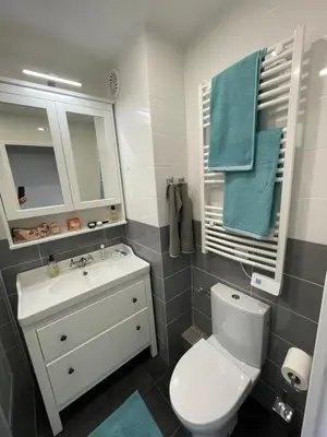 a bathroom with a toilet and a sink and blue towels at Nyrenoverad lägenhet med havsutsikt in Villefranche-sur-Mer