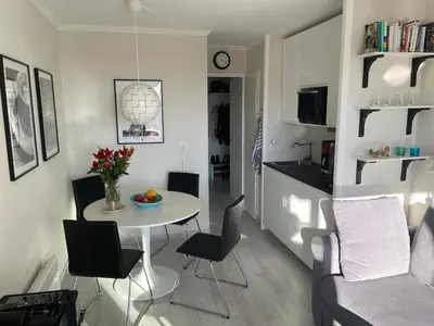 a kitchen and a living room with a table and chairs at Nyrenoverad lägenhet med havsutsikt in Villefranche-sur-Mer