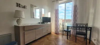 a living room with a dresser and a table and chairs at Nice Centre, Charmant Studio in Nice