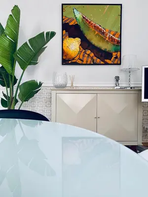 a living room with a table and a painting on the wall at Villa Bagatelle - Luxury apartment in Nice