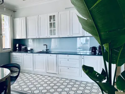 a kitchen with white cabinets and a green plant at Villa Bagatelle - Luxury apartment in Nice