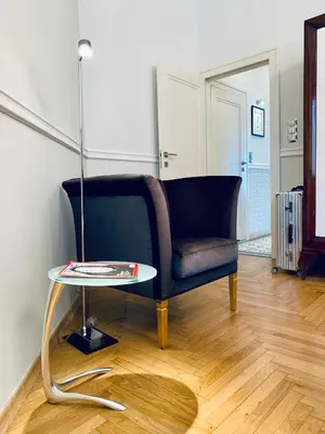 a living room with a blue chair and a table at Villa Bagatelle - Luxury apartment in Nice