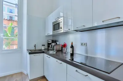 a white kitchen with white cabinets and a microwave at MY CASA - LIBERTÉ - Spacious Apartment City Center w AC in Nice