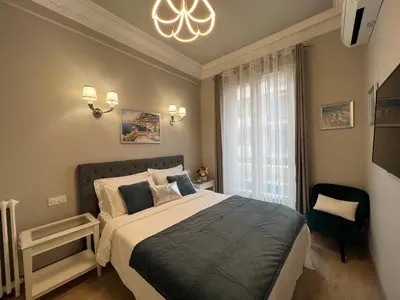 a bedroom with a large bed and a chandelier at D’AZUR-35 in Nice