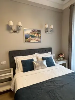 a bedroom with a large bed with blue pillows at D’AZUR-35 in Nice