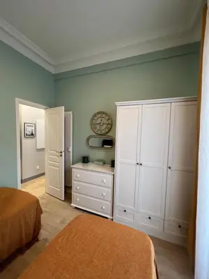 a bedroom with white cabinets and a bed and a table at D’AZUR-35 in Nice