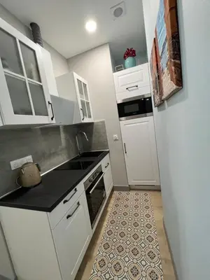 a small kitchen with white cabinets and a sink at D’AZUR-35 in Nice