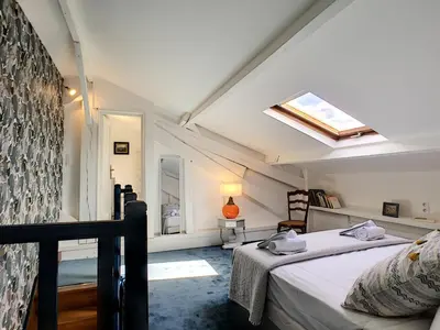 a attic bedroom with a bed and a skylight at Nestor&Jeeves - TOUCAN DUPLEX TERRACE - Hyper center - Top floor in Nice