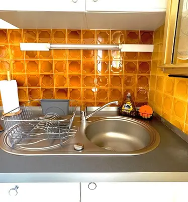 a kitchen sink with a dish drying rack next to it at Charmant Studio en bord de Mer in Nice