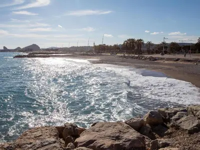 a beach with rocks in the water and the ocean at Apartment La Pinède-2 by Interhome in Le Puits