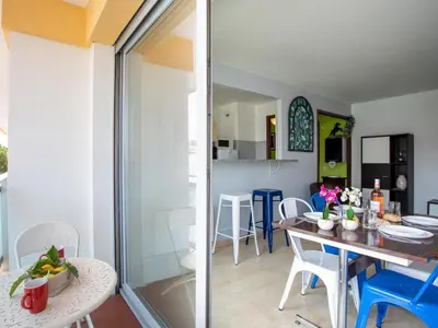 a living room with a blue couch and colorful stools at Apartment La Pinède-2 by Interhome in Le Puits