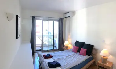 a bedroom with a bed with a large window at **** Panoramic Top Roof in Beaulieu **** in Beaulieu-sur-Mer