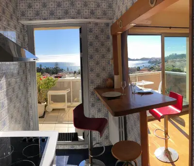 a kitchen with a table and chairs and a balcony at **** Panoramic Top Roof in Beaulieu **** in Beaulieu-sur-Mer