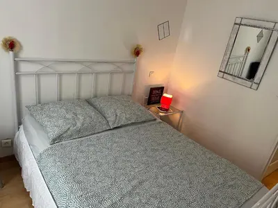 a bedroom with a bed and a table with a red candle at Luxe et charme Méditerranéen face à la promenade des Anglais in Nice