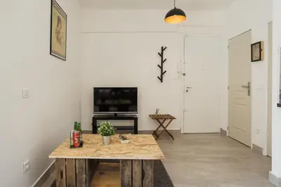 a living room with a table and a tv at Chic appartement Centre NICE au calme vue colline in Nice