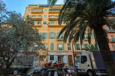a truck parked in front of a building with a palm tree at Chic appartement Centre NICE au calme vue colline in Nice