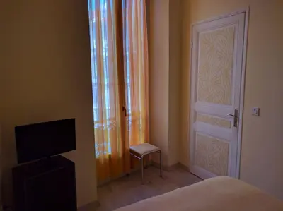 a bedroom with a door and a chair next to a door at Anderson apartment in Nice