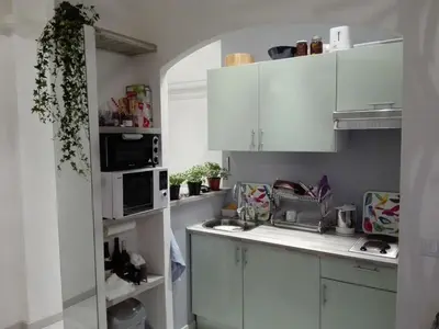 a small kitchen with white cabinets and a microwave at Anderson apartment in Nice