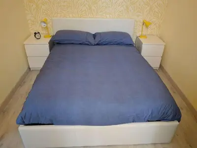 a bedroom with a bed with blue sheets and two night stands at Anderson apartment in Nice