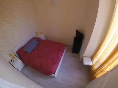 a small bedroom with a red bed and a television at Anderson apartment in Nice