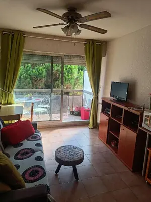 a living room with a couch and a ceiling fan at Studio Nice colline avec parking privé in Nice