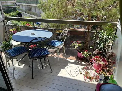 a balcony with a table and chairs and plants at Studio Nice colline avec parking privé in Nice