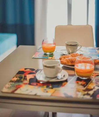 a table with two plates of food and cups and drinks at AzurAppart 3room Nice Promenade in Nice