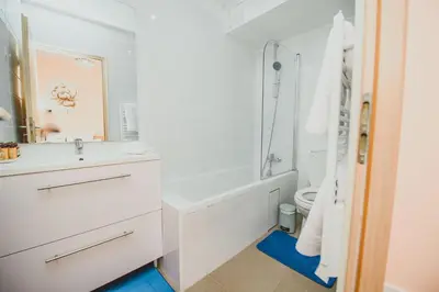 a white bathroom with a tub and a sink at AzurAppart 3room Nice Promenade in Nice