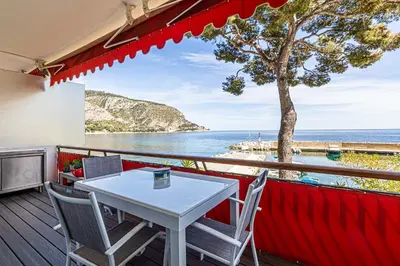 a table and chairs on a balcony with a view of the ocean at Appartement Eze bord de mer in Èze