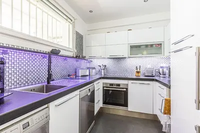 a kitchen with white cabinets and purple counter tops at Appartement Eze bord de mer in Èze